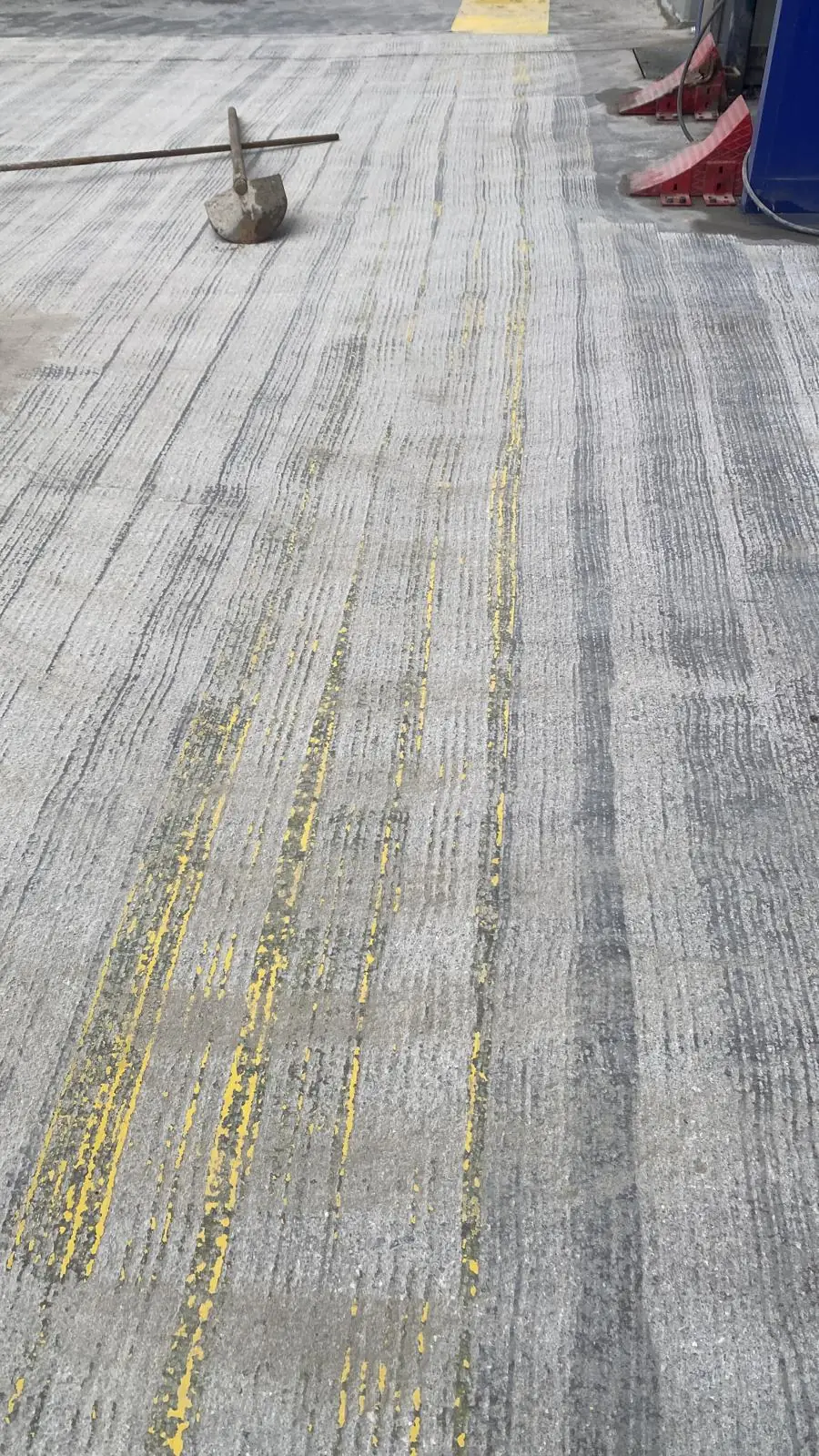 Eski sarı çizgilerin silimle alındığı beton zemin