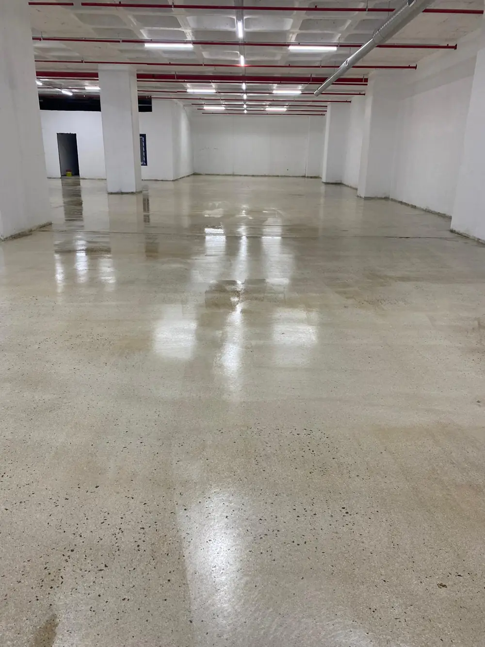 Işıkları yansıtan geniş parlatılmış beton hol